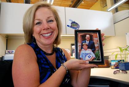On her desk, Malinda Whitson keeps a photo of her son, Drew, with Duke football head coach David Cutcliffe. Photo by Bryan Roth.