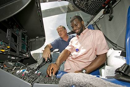 Marcus Jones (light shirt), a student at N.C. Central University, inspects a radio on a Duke Medicine Lifeflight helicopter along with OIT technician Scott Hudson. Marcus has worked through the summer as an intern with Duke's Office of Information Techno