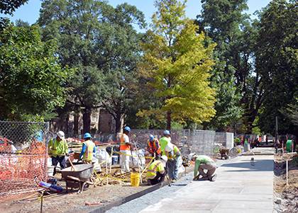 Crews inspect a portion of the upgraded sidewalk installed outside the Allen Building. It's part of a process to enhance irrigation and landscape health on Abele Quad. Photo by Bryan Roth.