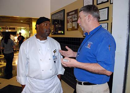 Tony Smith, a production worker with Duke Dining, chats with David Williams, Duke Police's crime prevention manager, during a past