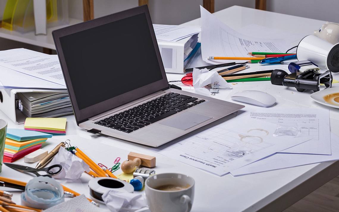 A messy desk with a laptop