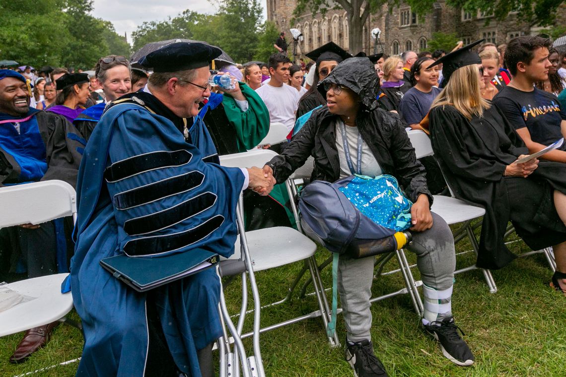 President Vincent Price moved down from the covered platform to sit in the rain next to first-year student Della Crawford. Photo by Megan Mendenhall.