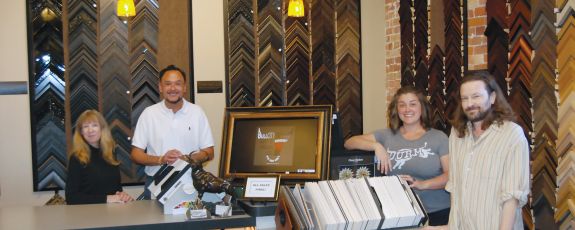 Left to right, Bull City Art & Frame staff Michelle Draughon, Lewis Bowles, Tiffany Bowles, and Will Rote stand ready to help frame cherished items. Photo by Jack Frederick.