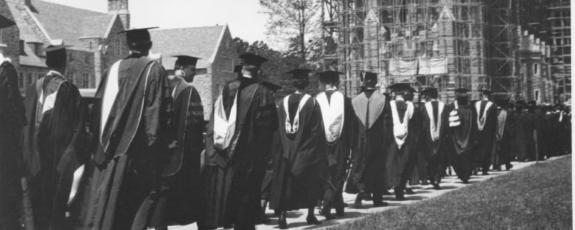 The faculty procession for the 1931 commencement held in Page Auditorium. In the background, Duke Chapel is under construction. 