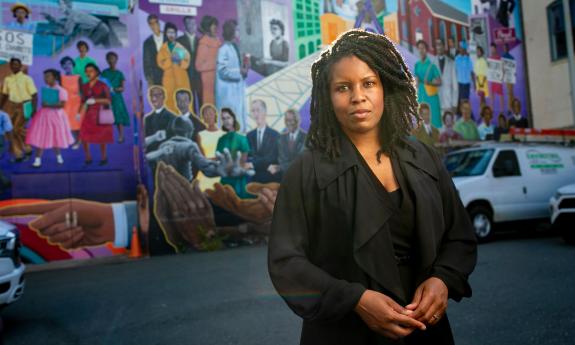 Candis Watts Smith, pictured in front of colorful Durham mural.