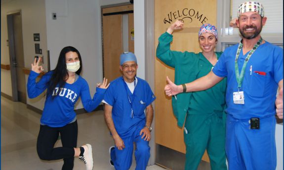 Representatives from Running Epidurals pose after their Get Moving Challenge victory in a non-clinical space of Duke University Hospital.