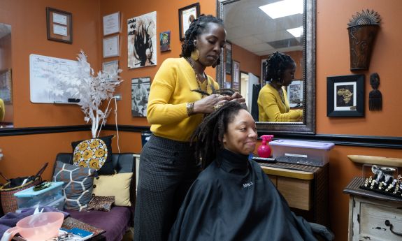 Aliaha Austin, graduate student at the Sanford School of Public Policy, gets her hair styled by Jeunesse (Jey) Hall, stylist and owner of Natural Roots by Jey on University Drive in Durham. 