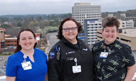 From left to right, Erin Leshowitz, Sabrina Wilkerson and Molly Gooden gather together on the roof of Duke University Hospital. Photo by Jack Frederick.