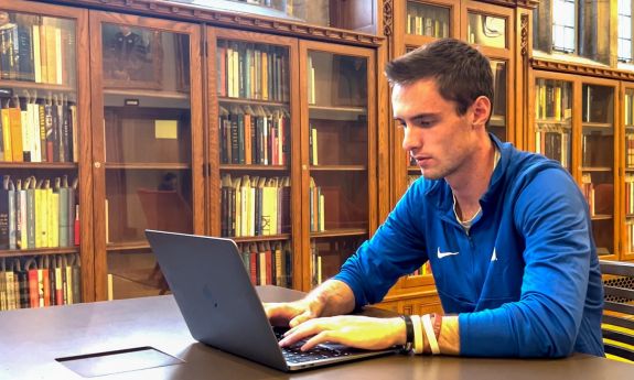 Duke Senior Danny Collins works on his laptop in the Gothic Reading Room
