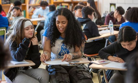 Junior Bianca Ingram, center, coaches Alia Montañez, 12, on vocabulary and lyrics. 