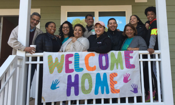 A resident of a Duke-built Habitat House celebrates with her family.