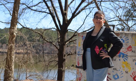 Woman standing next to neurodiversity painted sign