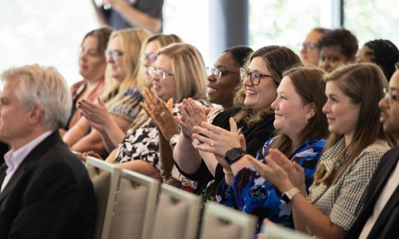 A row in an audience claps