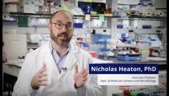 Nicholas Heaton, PhD sitting in a lab talking to the camera