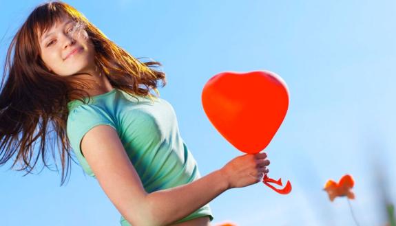 young woman hold balloons in the shape of a heart
