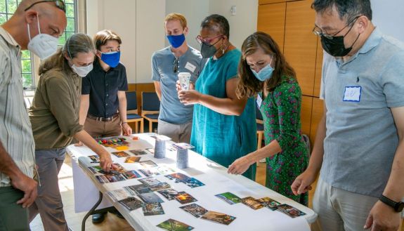 At a retreat, Duke climate change faculty fellows become familiar with Climate Fresk, a climate change board game that will be part of the course.