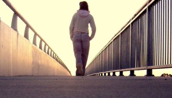 teen walking across bridge