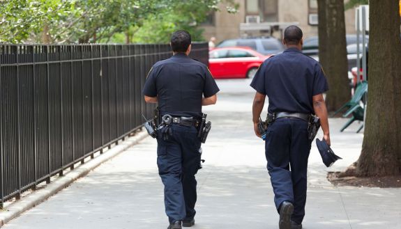 two police officers walking down a sidewalk