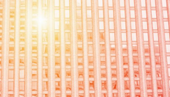 sun reflecting off of an all window building wall