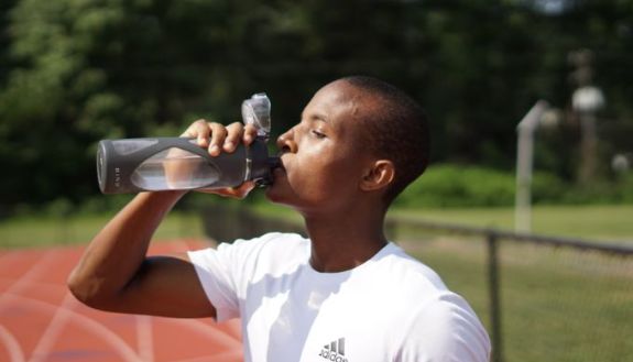 young athlete drinking water