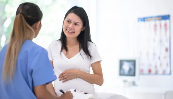 Stock photo of pregnant woman talking to a doctor. 
