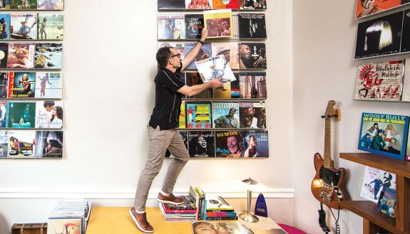 Wayne Norman in his office putting away an album