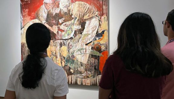 Students stand in front of the painting “Dr. Henry Bethune” by Hung Liu during a visit to the North Carolina Museum of Art. 