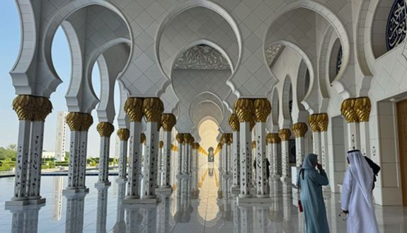 Ashley Ward (left), director of the Heat Policy Innovation Hub, attended COP28 in the United Arab Emirates. Here, she talks with staff at the Grand Mosque in Abu Dhabi about the traditional cooling methods deployed there.