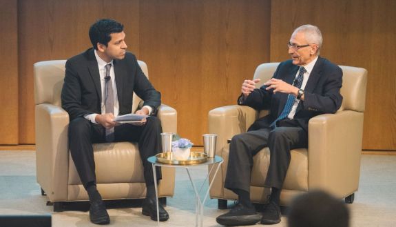 Ronnie Chatterji, left, talks with John Podesta during the conference exploring ways to increase private and public investment in fighting climate change.