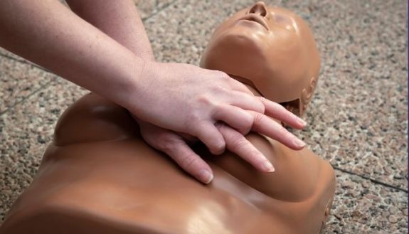 person performing cpr on woman mannequin