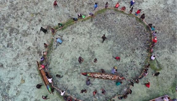 Arial shot of fisher people on the sand