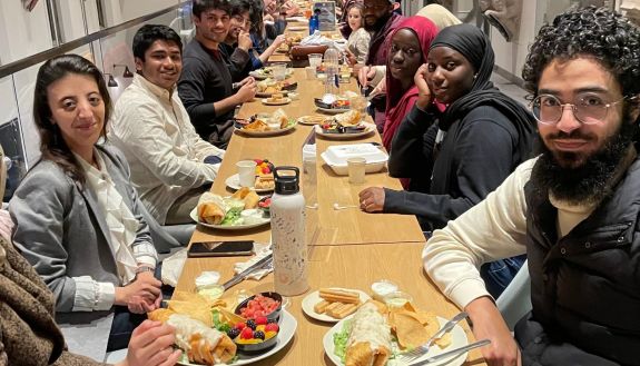 Rashad Rahman, third from left, and other Muslim students eating on campus during Ramadan in an iftar organized by the Center for Muslim Life.