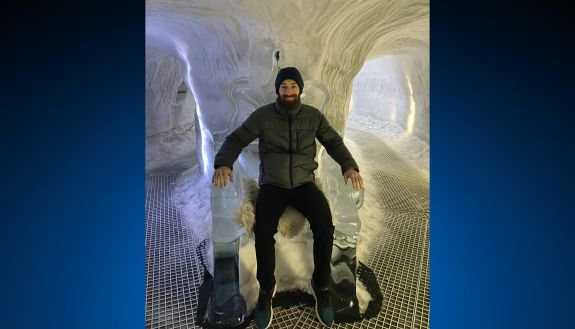 A man sits on an ice throne in an ice cave
