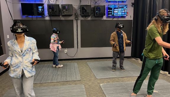 Four people with virtual realities goggles on