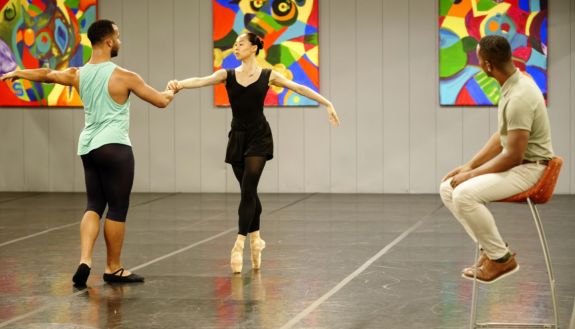 Two dancers with one person looking on
