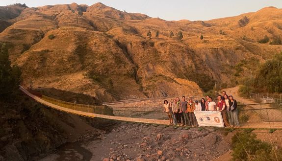 A pedestrian bridge against a mountain backdrop