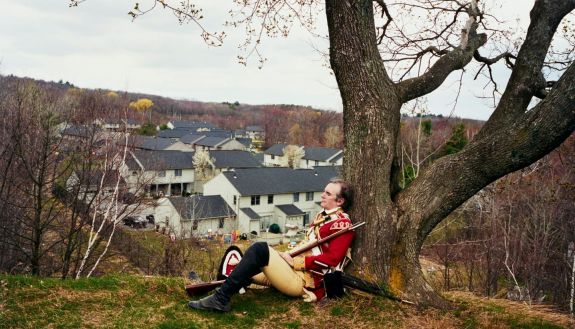 Re-enactment of a British redcoat leaning against a tree