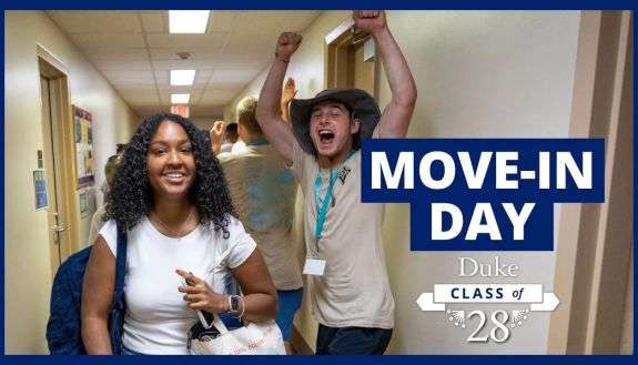 Move-in Day video thumbnail showing a student cheering in a dorm hall as another student walks by