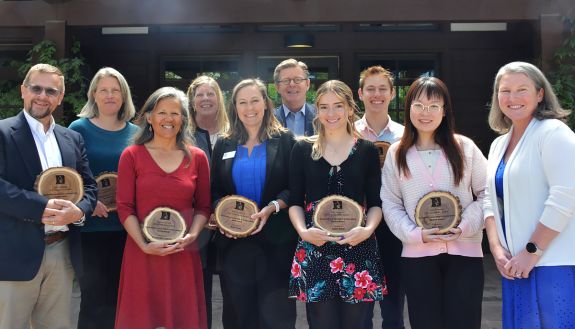 A group of people posing with awards