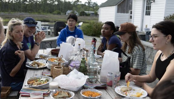 People sitting around a table talking and eating 