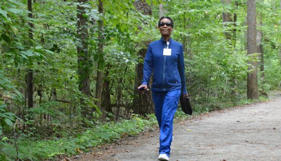 A woman walking on a forest trail.