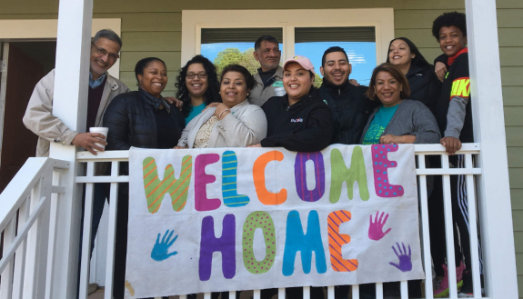 A resident of a Duke-built Habitat House celebrates with her family.