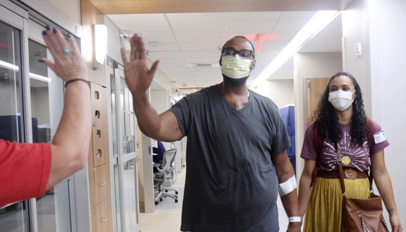 Heart patient Donavan Harbison walks with his wife Lindsey Harbison following the operation.