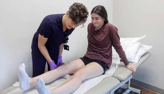A person examining someone's knee
