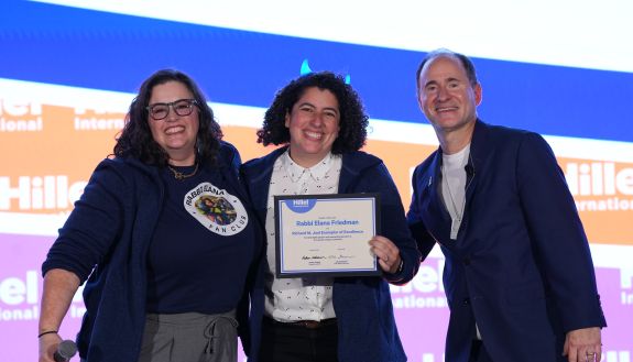 Rabbi Elana with award and two people on either side of her