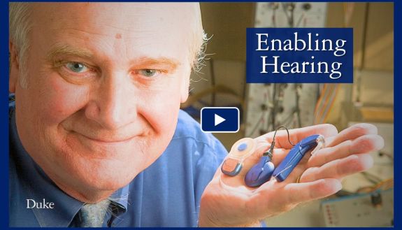 Blake Wilson holding a cochlear implant