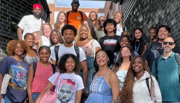 A bunch of people smiling looking at the camera