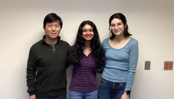 Three students looking at the camera and smiling