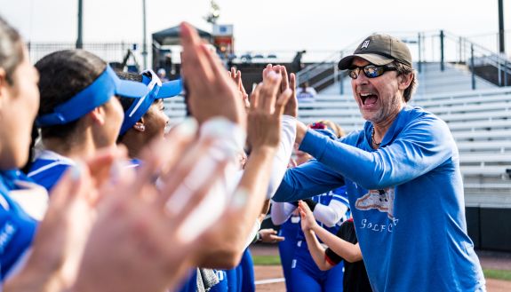 A Duke professor gives high-fives to the Duke softball team before a game in 2024