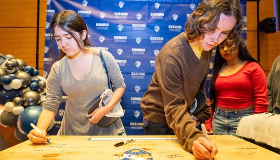 Students sign their acceptance to the Early College of Health Sciences as part of a ceremony honoring the school’s inaugural class.